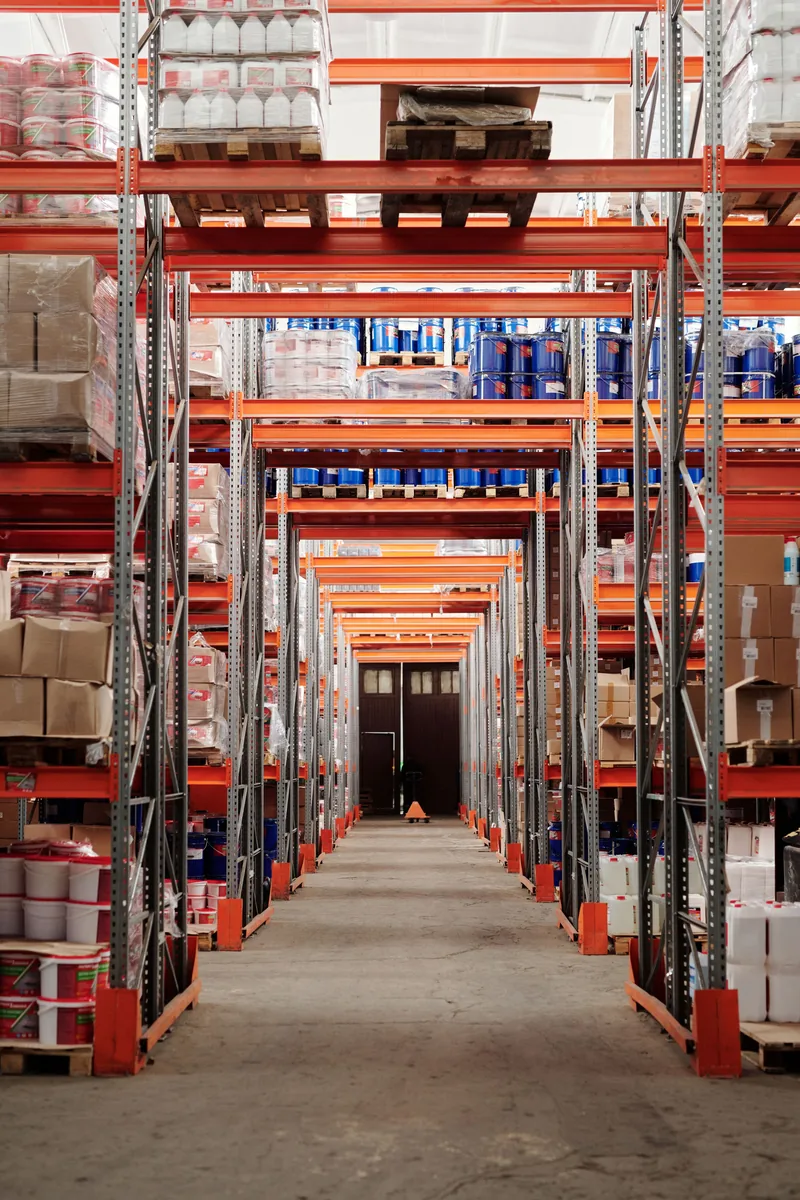 Longue allée avec rayonnages identifiés et marchandises stockées