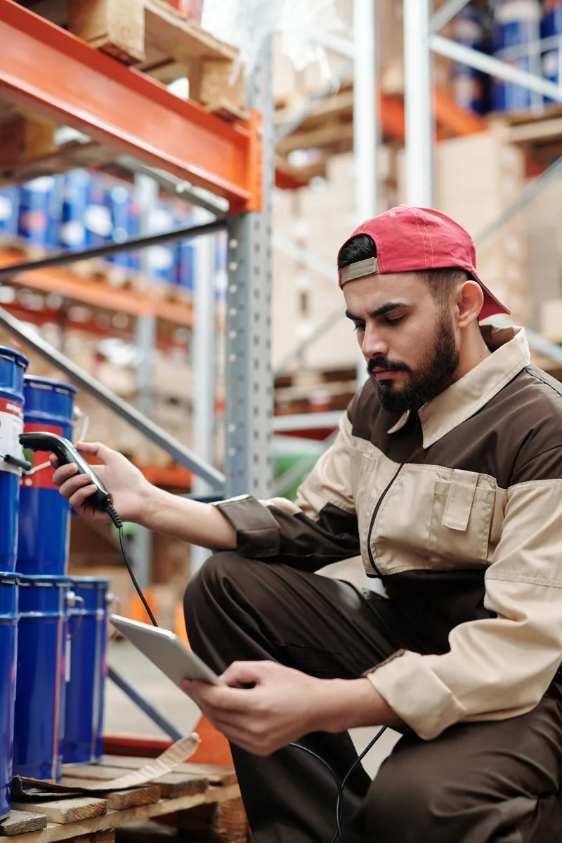 Employé portant une casquette rouge et utilisant un appareil mobile