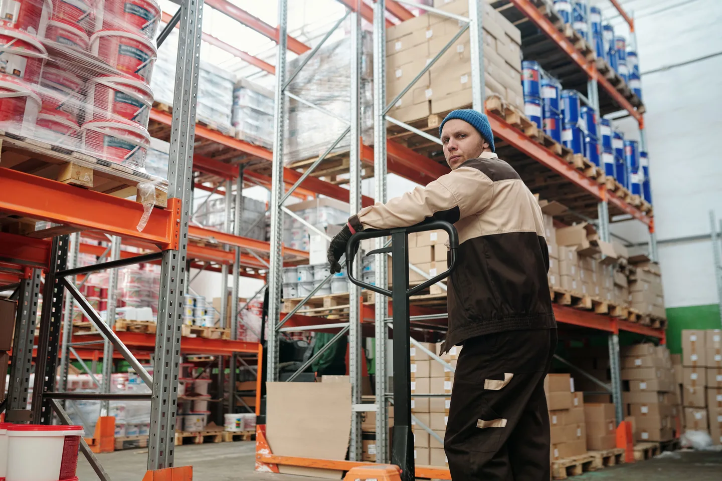 Employé déplaçant de la marchandise avec un transpalette