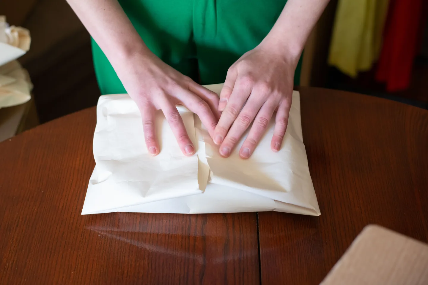 Mains enveloppant un vêtement pour l’expédition